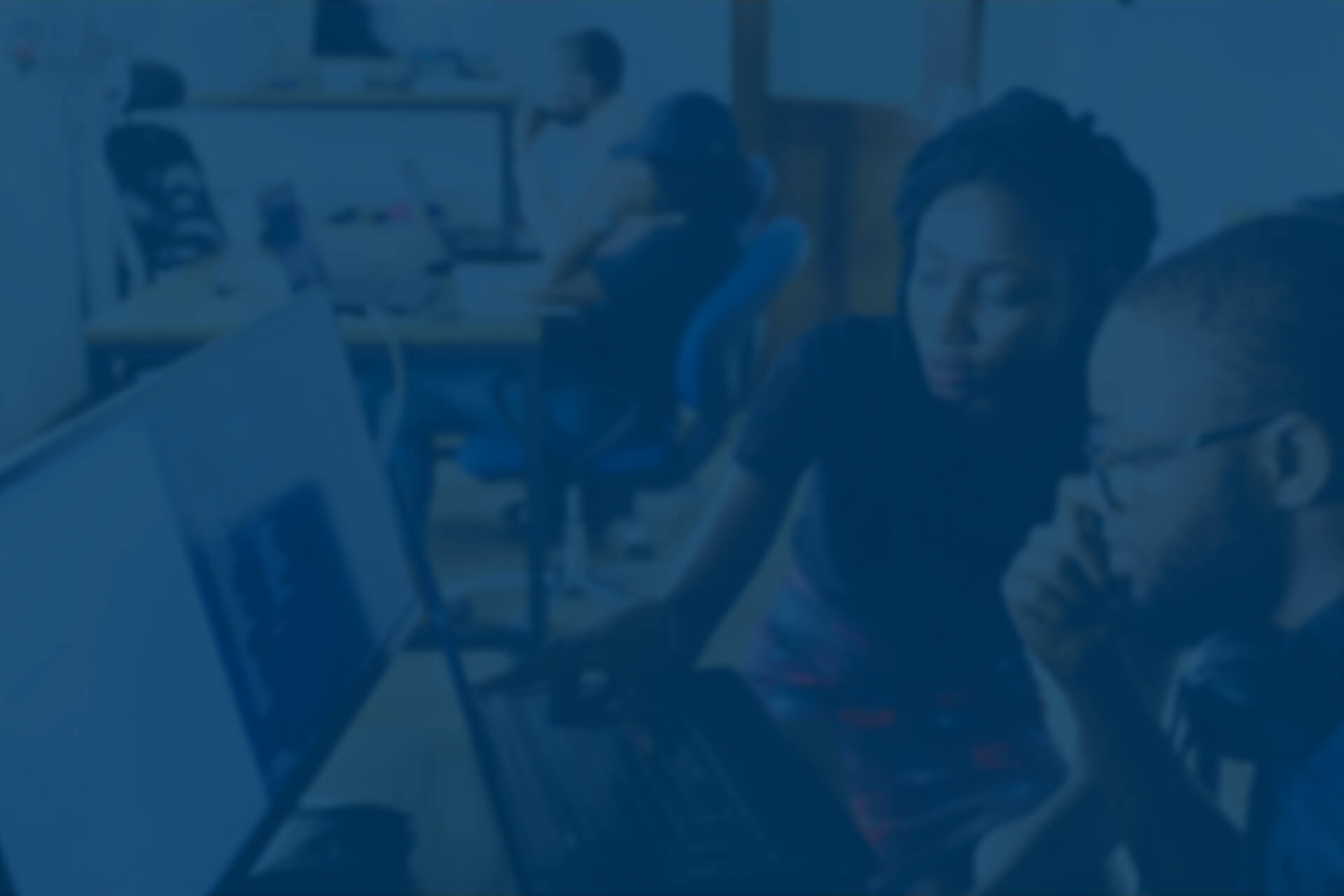Two ICE InsureTech employees collaborating on a computer, reviewing project work within our advanced insurance software